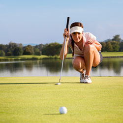 woman golfer lining up putt