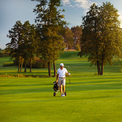 golfer walking pulling bag on fairway