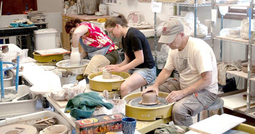 pottery making class with students working on wheels