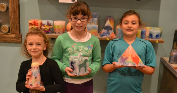 3 young girls holding homemade candles