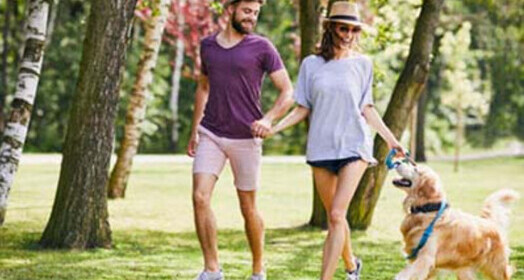 couple walking dog in park