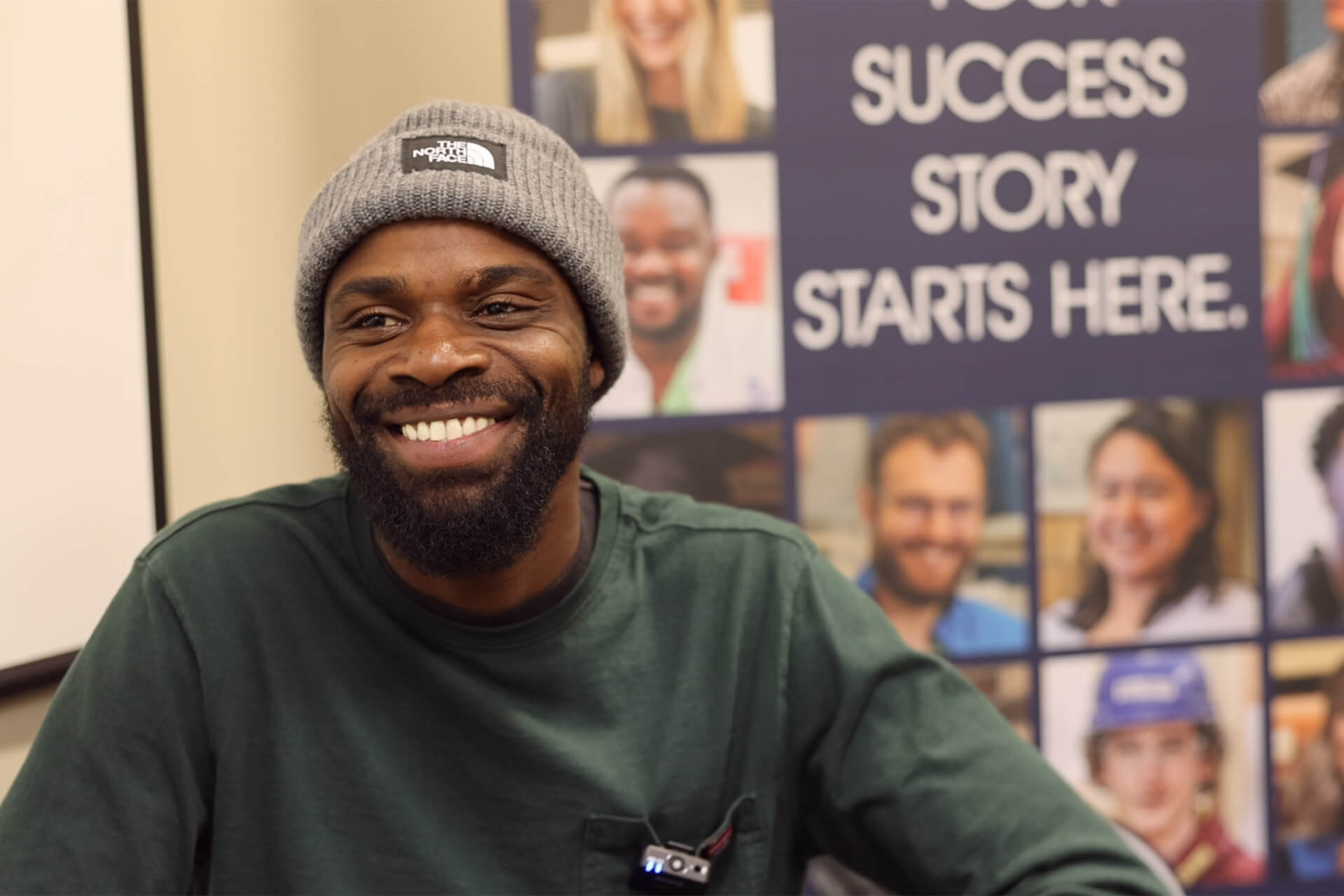 4-4_BlogHeader-Innovate28 Photo of a man who is wearing a hat and smiling with a backdrop that says "Your success story starts here."