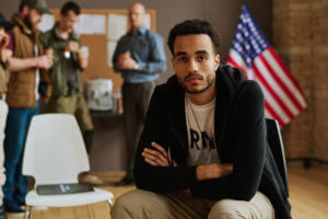 Army veteran sits in a room looking into the camera, looking sad