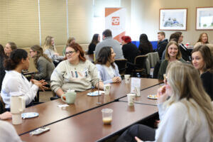 A group of young professionals sit at table networking