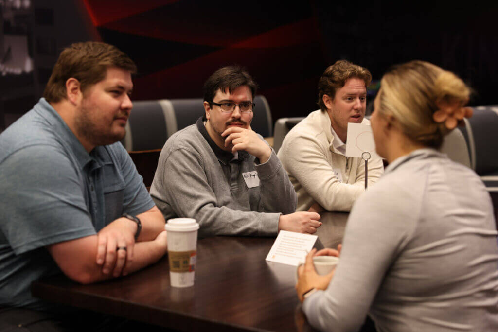 Young professionals sit around the table networking during YPN's Breakfast Club event.