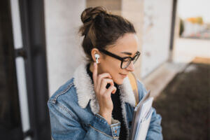 Woman listening to podcast through earbuds. Stock image from Envato.