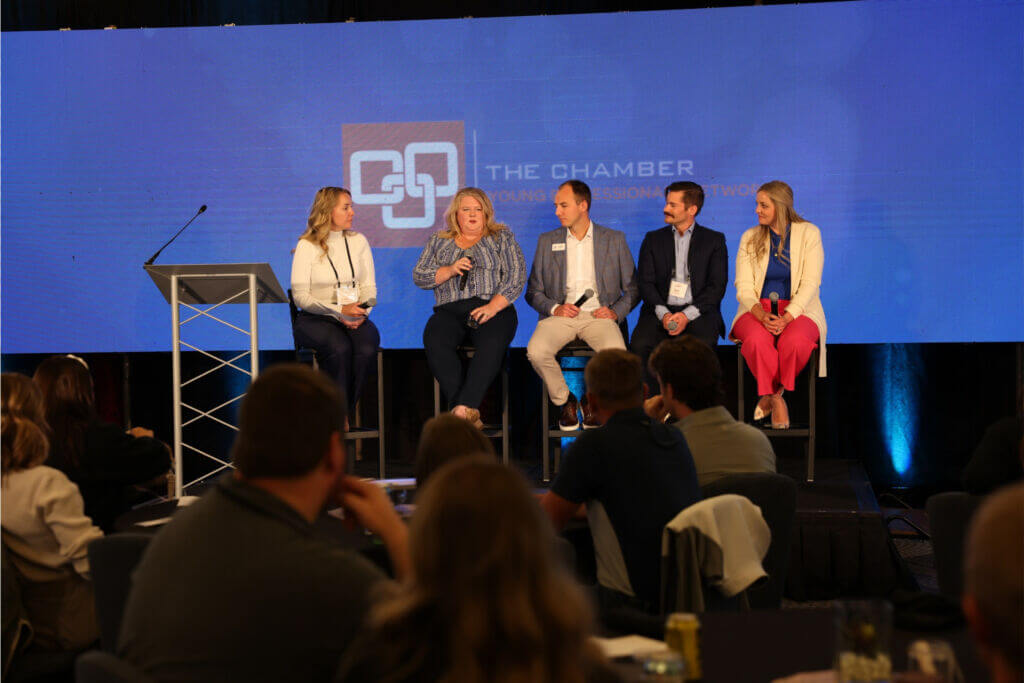 Five panelists sit on stage presenting during the 2024 YP Summit.