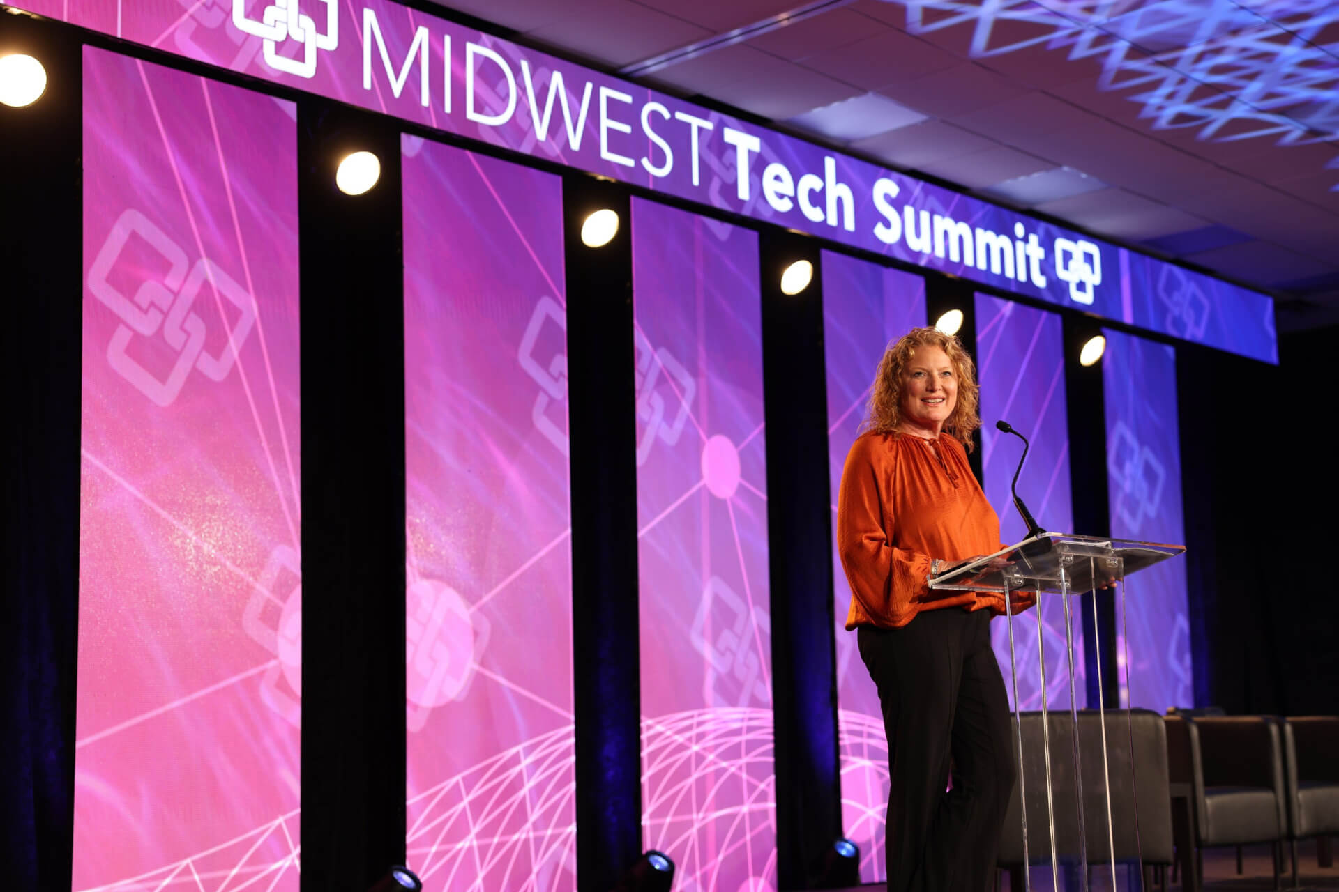 Shannon Full, Chamber President and CEO, stands at the podium at the Midwest Technology Summit to prepare attendees for discussion on topics like AI adoption.