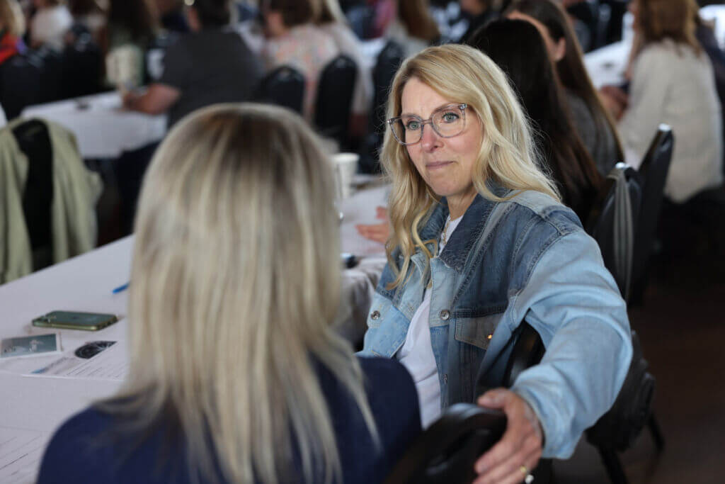 Two women connect over leadership drift at the July 2025 Women Connect event: Reclaiming Yourself in Leadership.