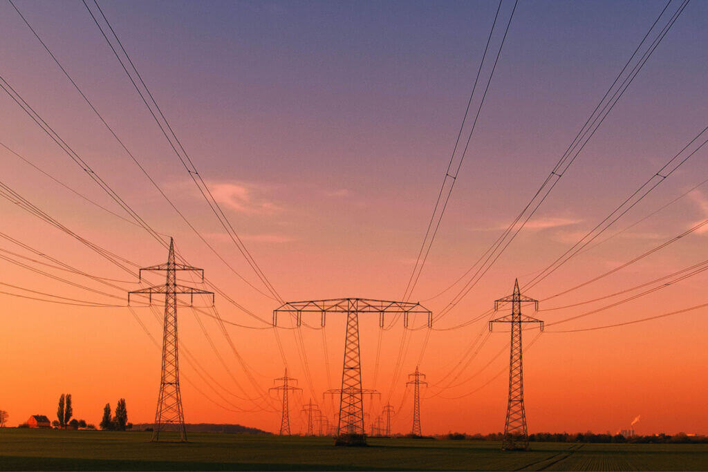 Sunset over power lines and open fields, highlighting the energy trends driving innovation across the Midwest.