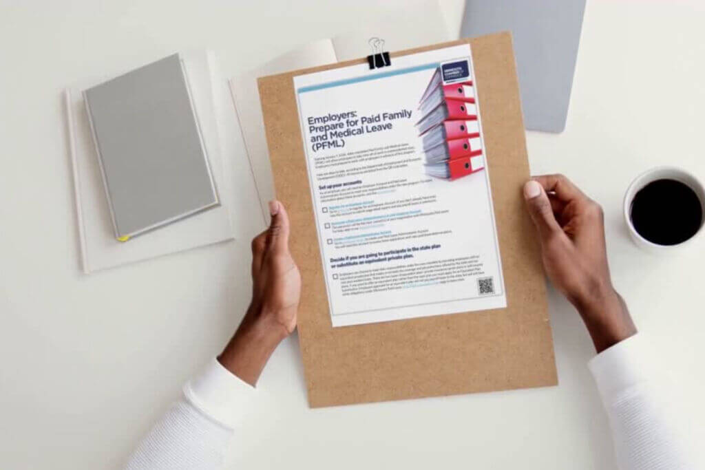 Person reviewing a PFML compliance checklist for employers about Minnesota’s Paid Family and Medical Leave program on a clipboard.