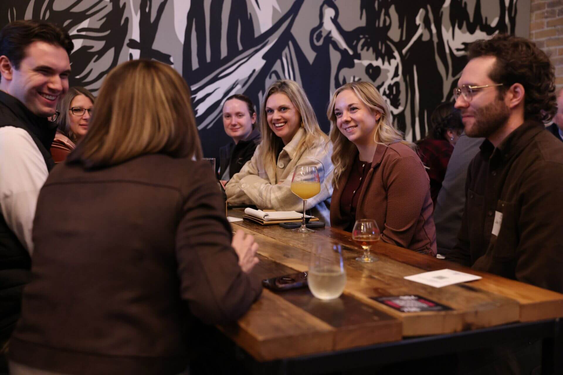 Attendees gathered around a table in discussion during the Civics on Tap civic engagement event hosted by the FMWF Chamber at Drekker Brewing Company in Fargo.