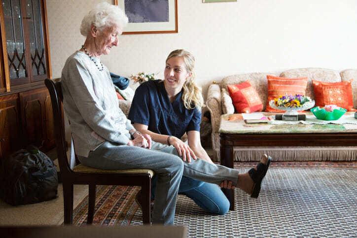 senior adult doing physiotherapy supported by therapist