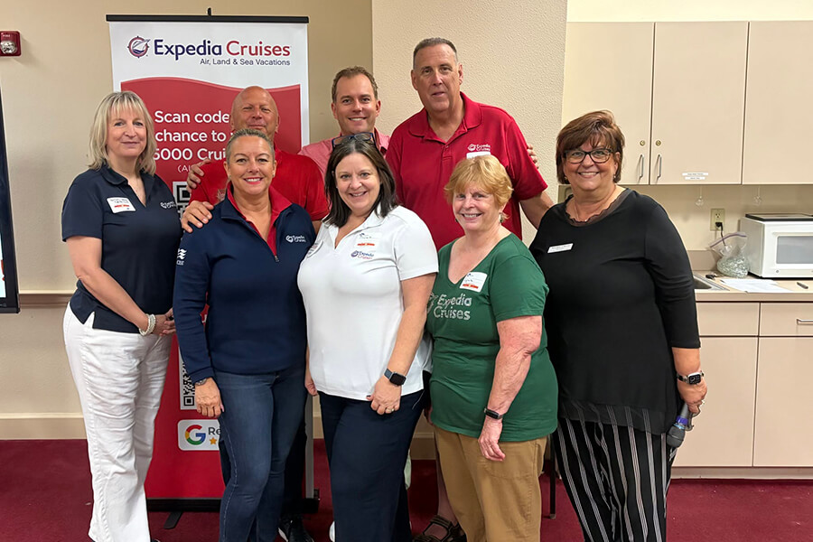 Group of four people posing together at an Expedia Cruises event booth