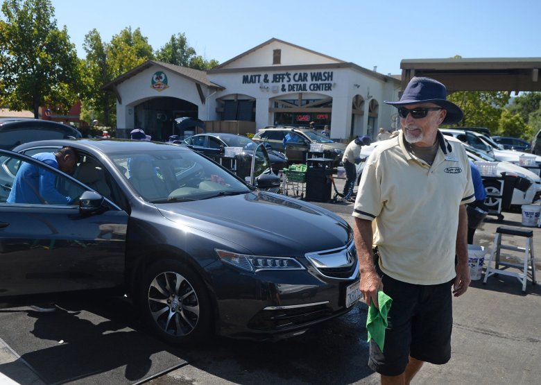 Matt Broderick, co-owner of Matt and Jeff's Car Wash, walks among client cars as his staff cleans them in Novato Wednesday. (Alan Dep/Marin Independent Journal)