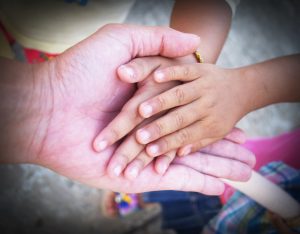 Hand of an elderly holding hand of younger