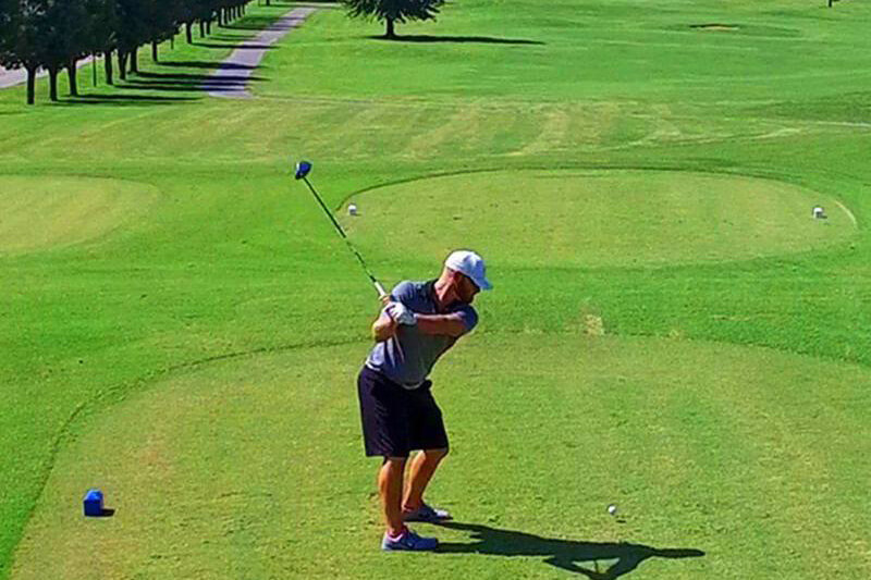 golfer teeing off