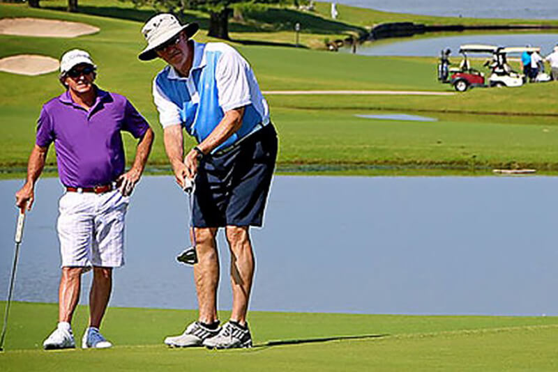 two golfers putting