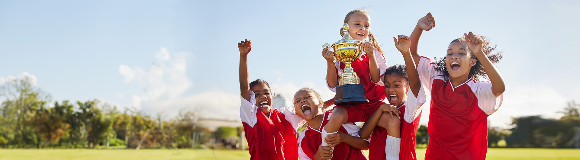 Kids carrying girl holding trophy