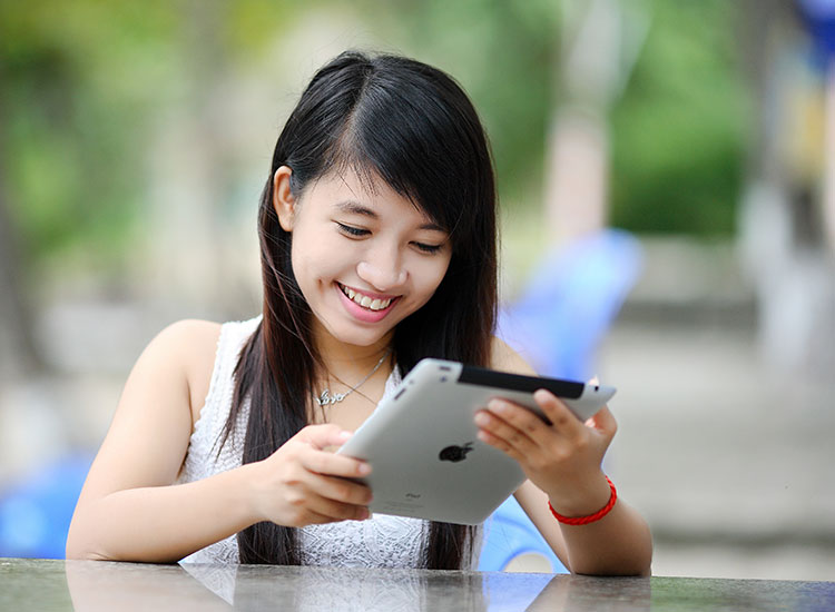 Person smiling and looking at an iPad