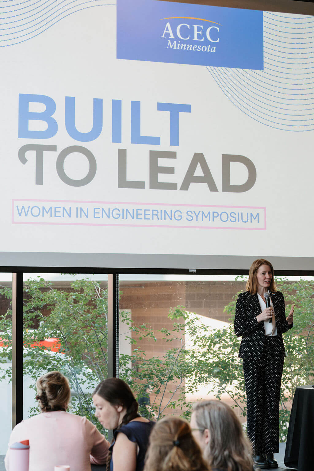 ACEC Minnesota President and CEO Megan Dayton opens the symposium beneath the Built to Lead title slide