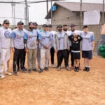 A team in matching gray jerseys lines up for a photo