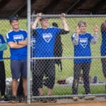 Players in Ayres jerseys cheer from behind the fence