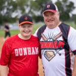 Two players in Dunham jerseys pose together on the field