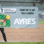 The Ayres Field Sponsor banner on the fence