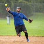 A pitcher in a blue jersey delivers a pitch