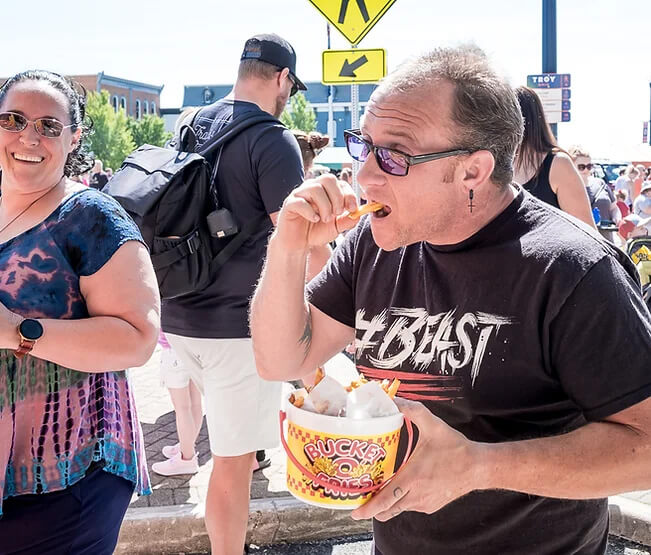 man eating bucket of fries