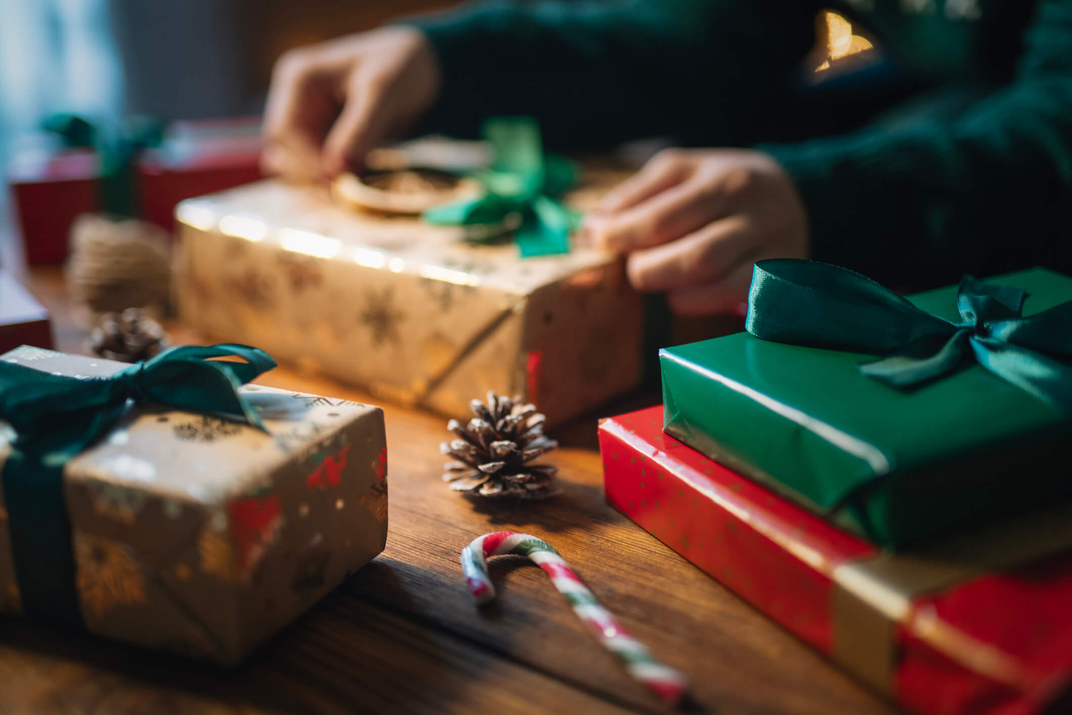 Close up of unrecognizable woman preparing Christmas presents in cozy atmosphere.