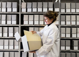 person viewing large box of documents in an archive