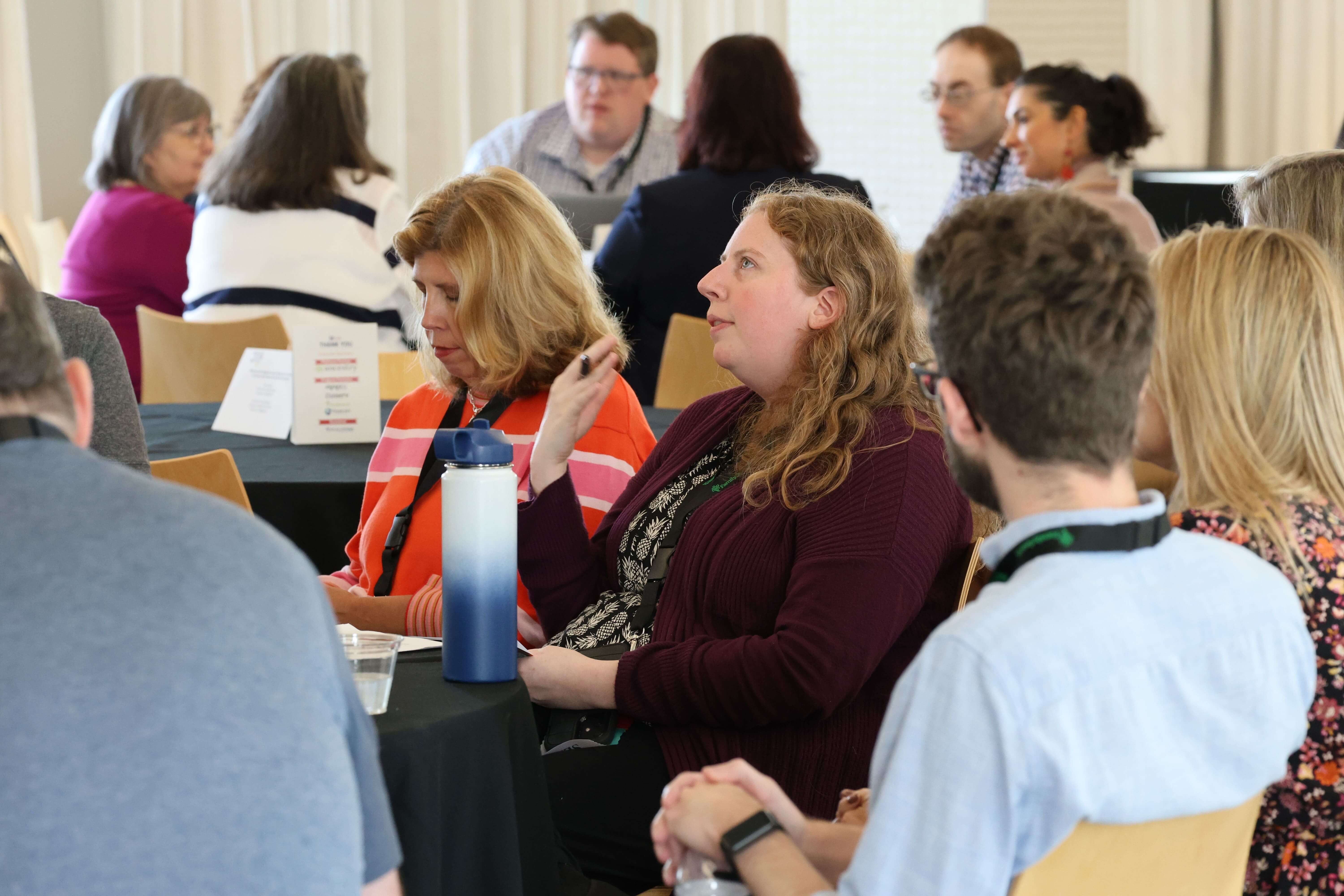 Attendees of the 2024 CoSA Annual Meeting discuss topics of interest around tables