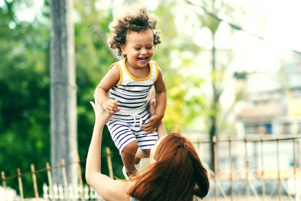 Mother lifting her smiling child up