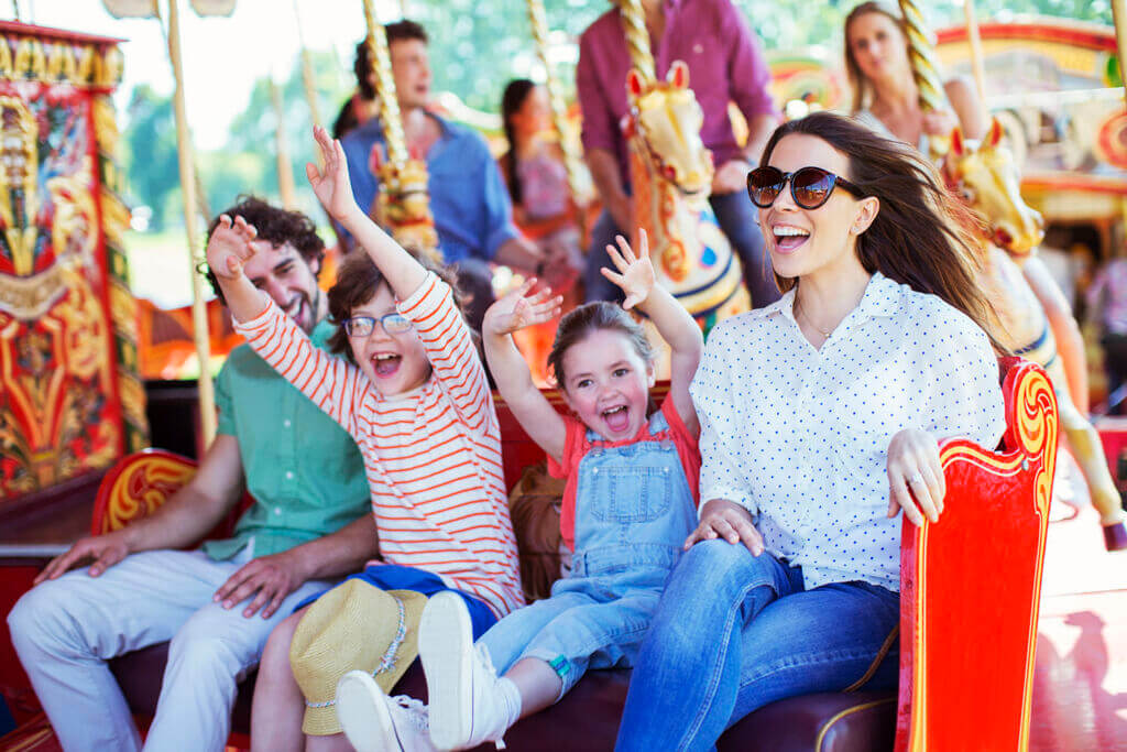 Family on carousel in amusement park Carnival