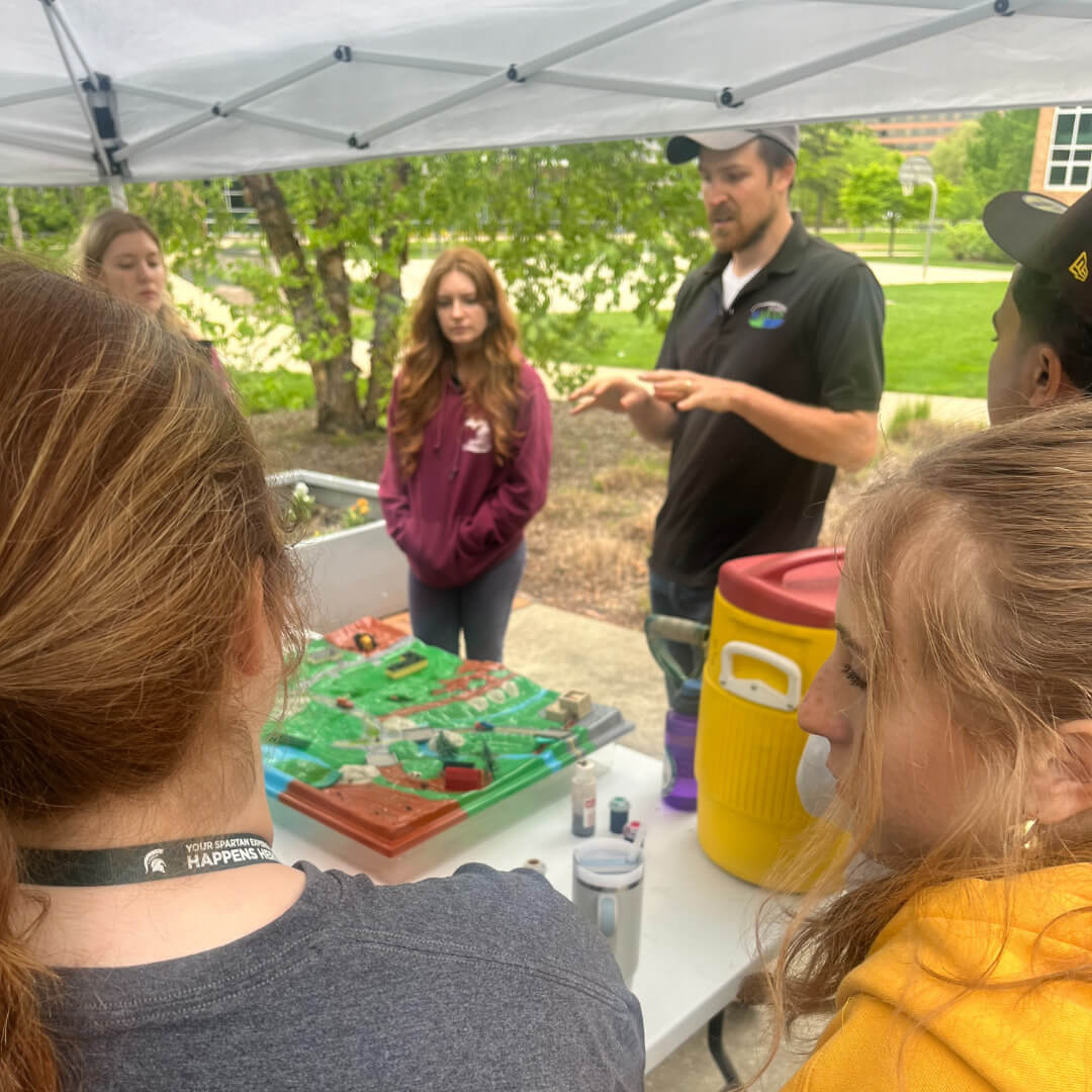 Inside a hoop house with vegetable rows and trellising
