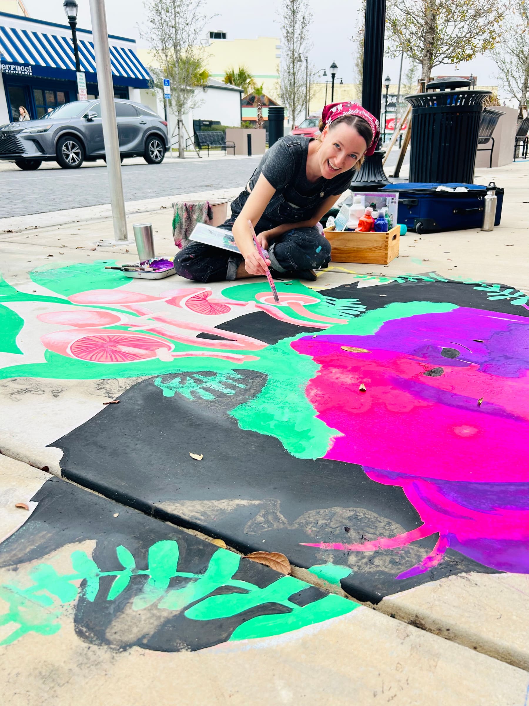 Artist Heather Clements painting colorful public art in Downtown Panama City, Florida