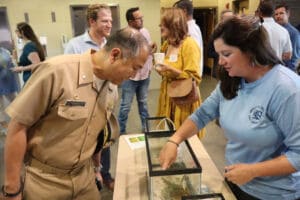 Bay County tourism representative sharing an educational display with a community member
