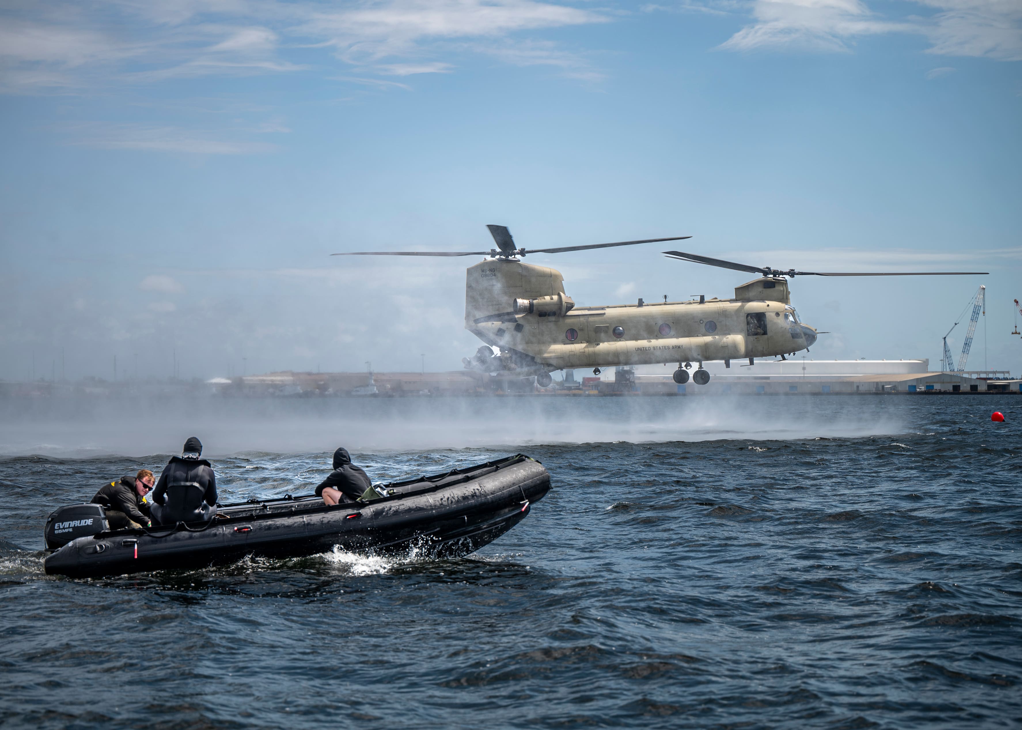 Military helicopter and small craft conducting training over St. Andrews Bay near Naval Support Activity Panama City