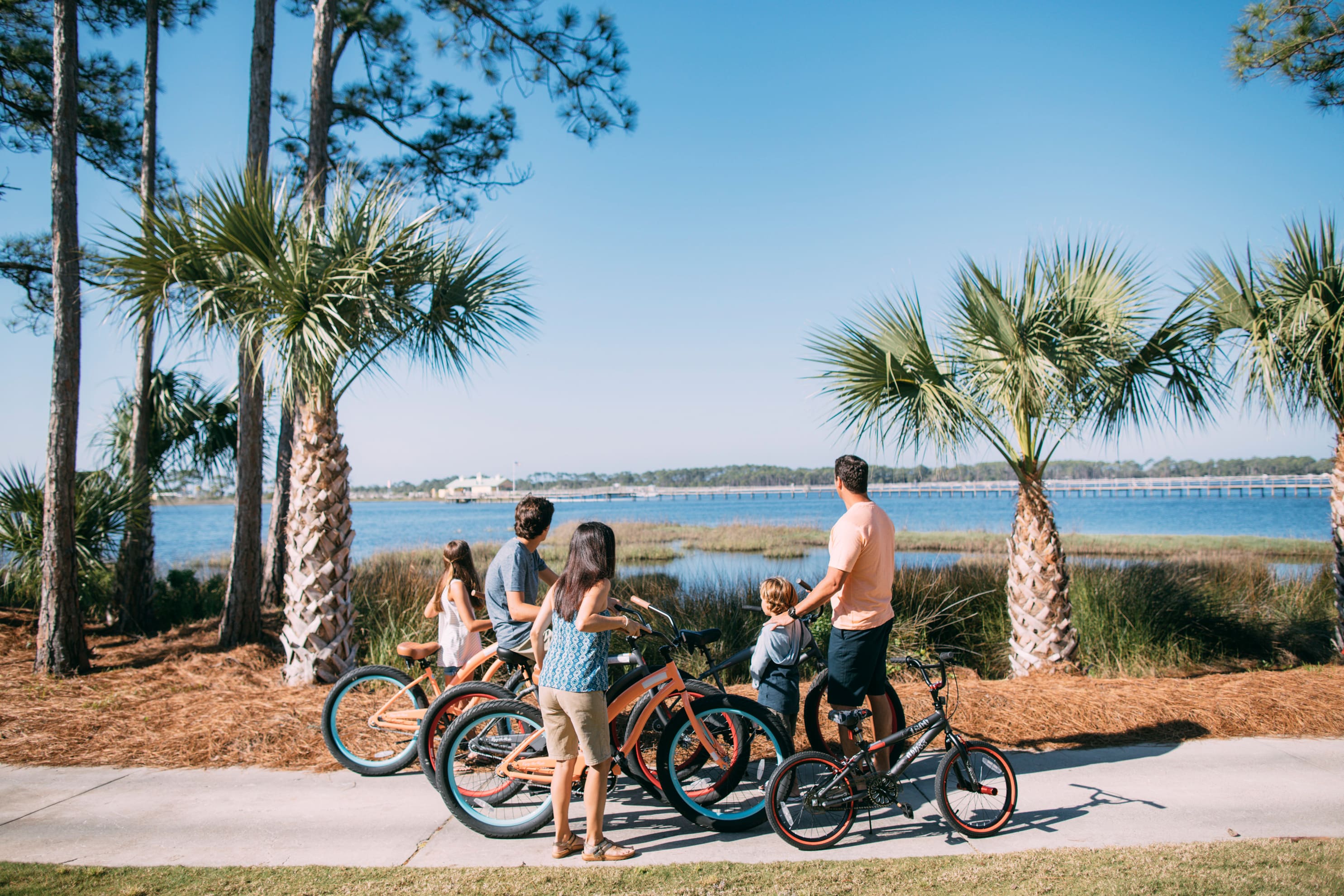 Family biking along a waterfront trail in Panama City Beach, Florida