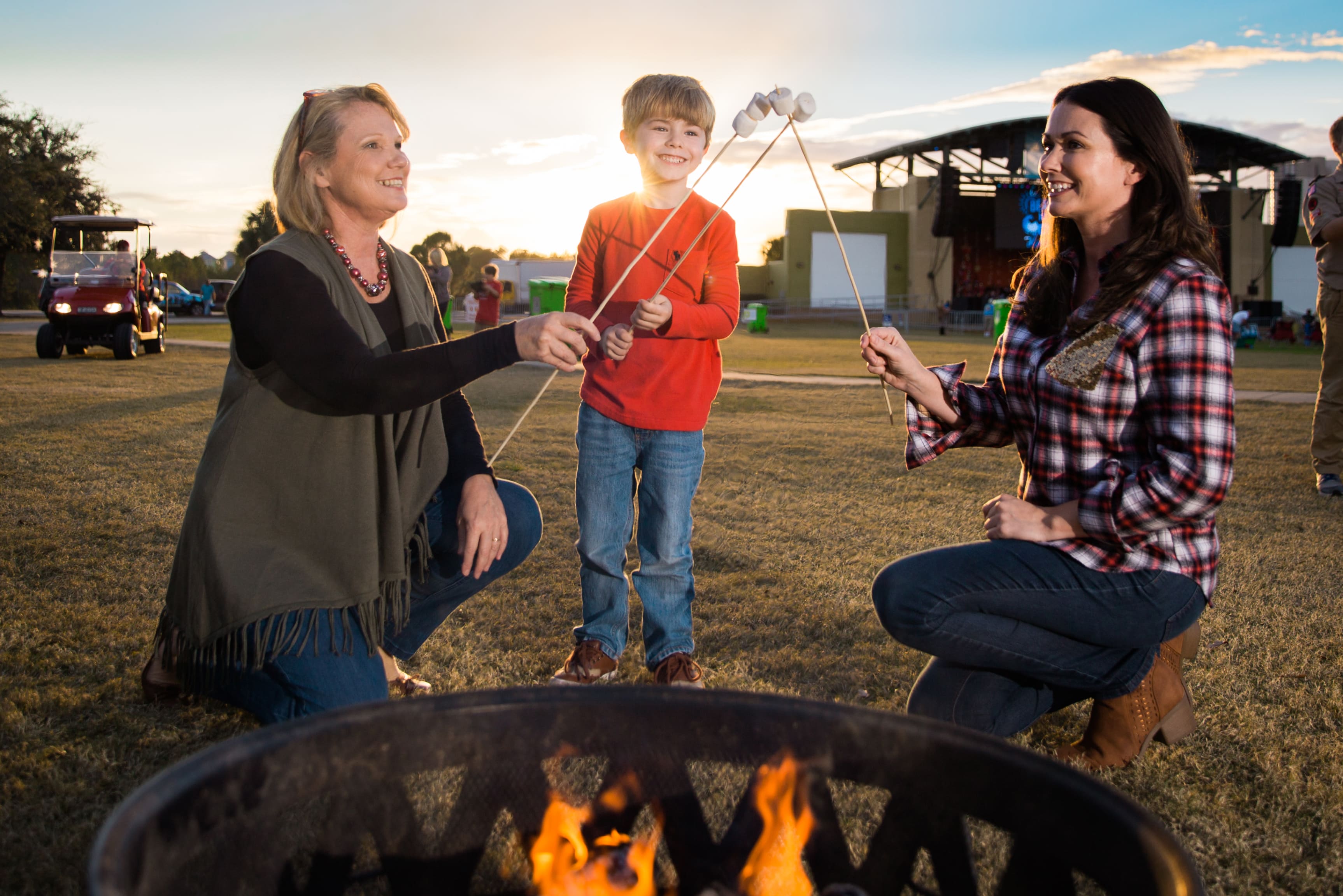 Family roasting marshmallows together at an outdoor community event in Panama City Beach