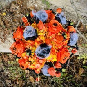 Festive orange floral design for Halloween with scary black spider and cobwebs