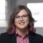Headshot of smiling woman with brown hair and glasses