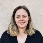 Sabrina is smiling and has long blond hair and is wearing a black shirt