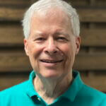 Jim is wearing a blue-green polo shirt