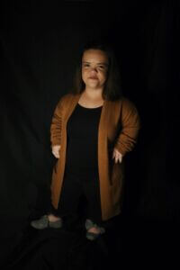 Kori Allen HeadShot Kori is wearing a brown cardigan over a black outfit