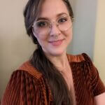 Leah is wearing a velvet burnt orange top