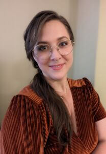 Leah Schoelles Headshot Leah is wearing a velvet burnt orange top