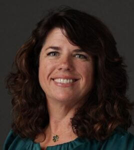 Shannon Black Headshot Shannon has dark wavy hair and is wearing a green top